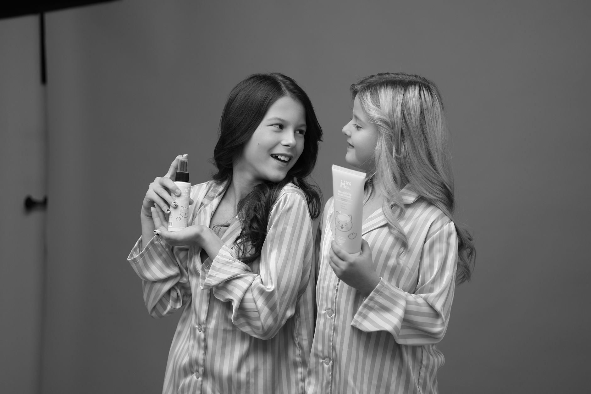 children in pajamas holding skincare products